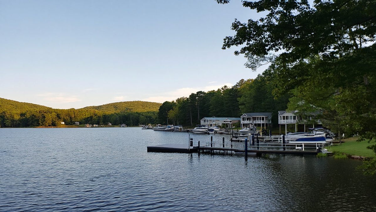 Lake homes with boat docks along a wooded shoreline on a calm afternoon