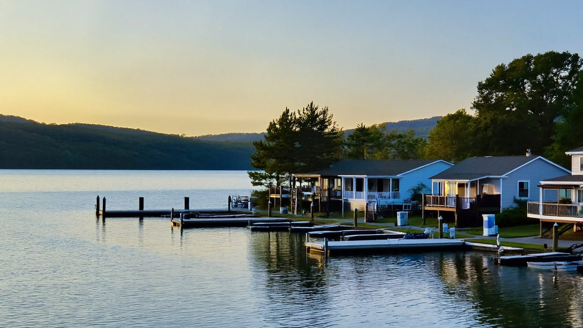 Row of lake houses with private docks along a calm lake at dusk
